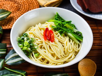 傻瓜乾拌麵，白色細麵拌辣渣，配蔥花、辣椒片與青菜